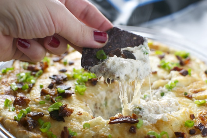 Crispy bacon cheese dip with melted cheese and green onions, cheese appetizer with crispy bacon pieces, gooey cheesy cheesy dip with bacon garnished with green onions, delicious cheesy bacon dip for parties and gatherings, relevance.