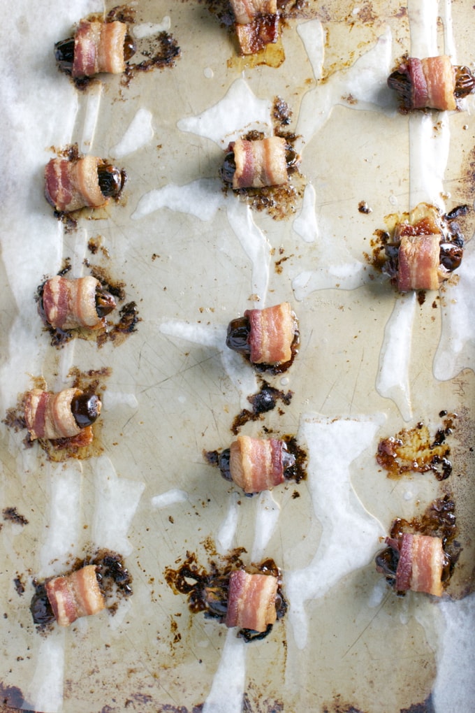 Bacon-wrapped stuffed dates with chocolate on baking sheet, close-up, from Stuck On Sweet.