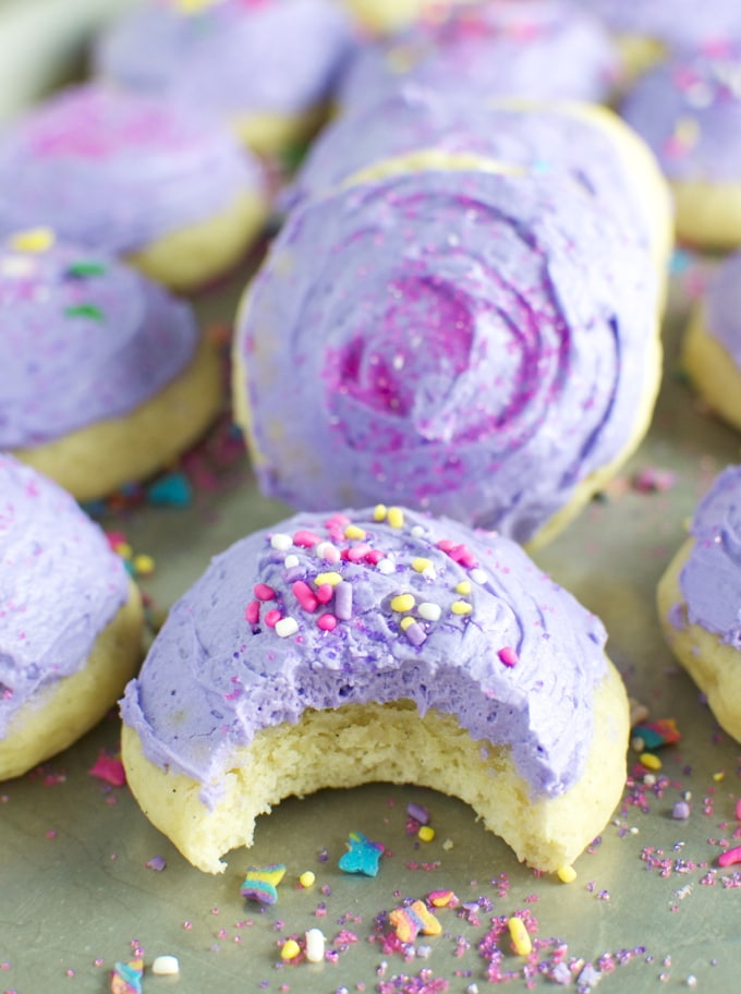Lavender glazed cookies with colorful sprinkles, close-up on a baking sheet, homemade dessert from Stuck On Sweet.