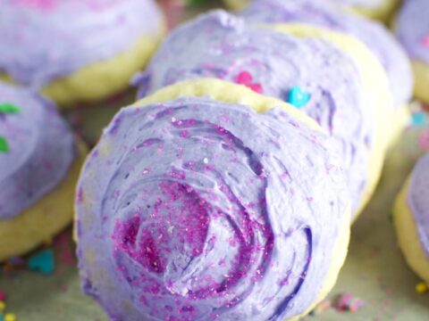 Rich, colorful lofthouse cookies with purple and pink frosting, sprinkles, and vibrant decorations perfect for celebrating special occasions and indulging in sweet treats.