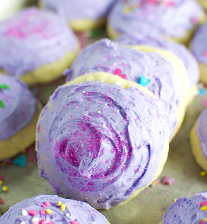 Rich, colorful cookies with purple and pink frosting, sprinkles, and vibrant decorations perfect for celebrating special occasions and indulging in sweet treats.