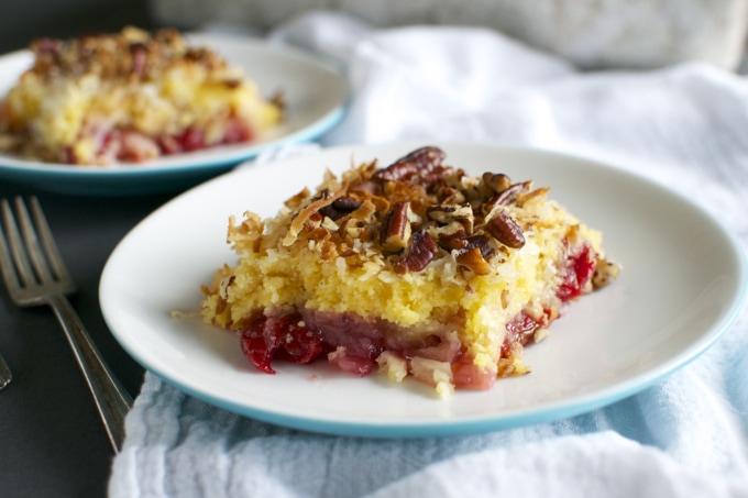 Creamy fruit cobbler baked dessert with a golden topping and cherry filling, served on a white plate for a delicious sweet treat.