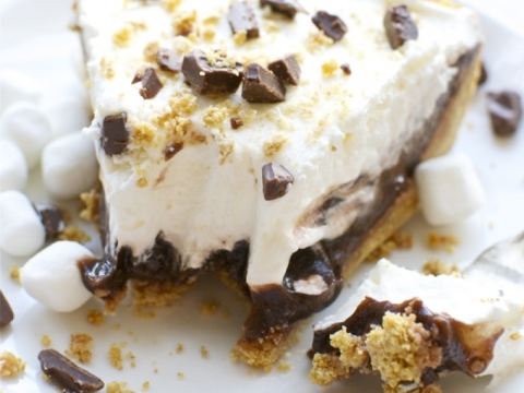 Creamy chocolate dessert with graham cracker crust, whipped topping, and marshmallow bits, topped with chocolate chunks and golden crumbs, perfect for sweet cravings and dessert lovers.