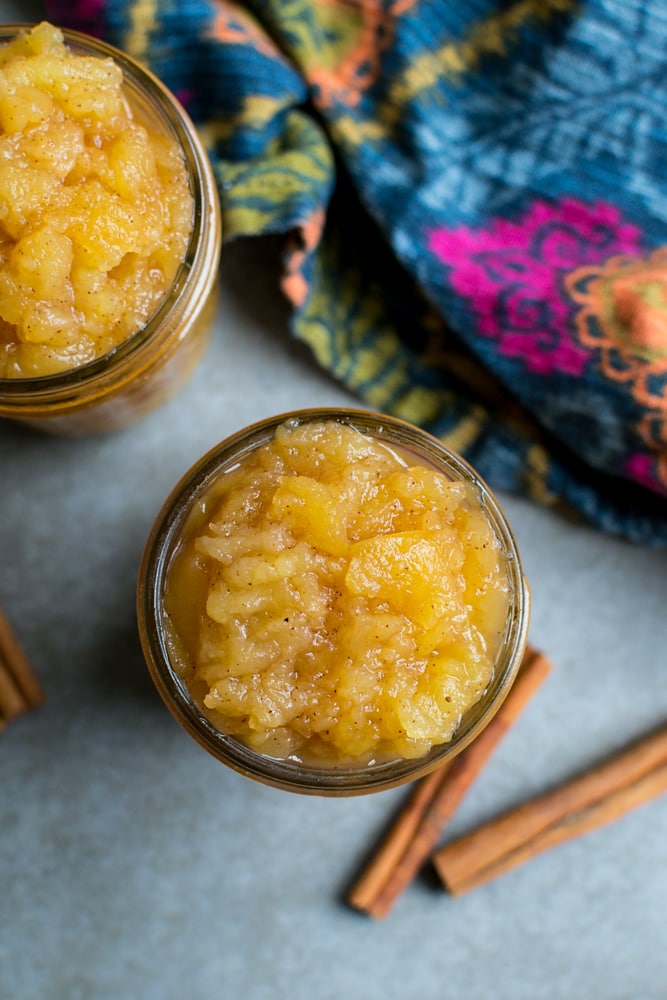Sweet homemade applesauce in glass jars, perfect for spreading on toast or biscuits. Homemade fruit preserves with warm cinnamon flavor, ideal for breakfast or snacking.