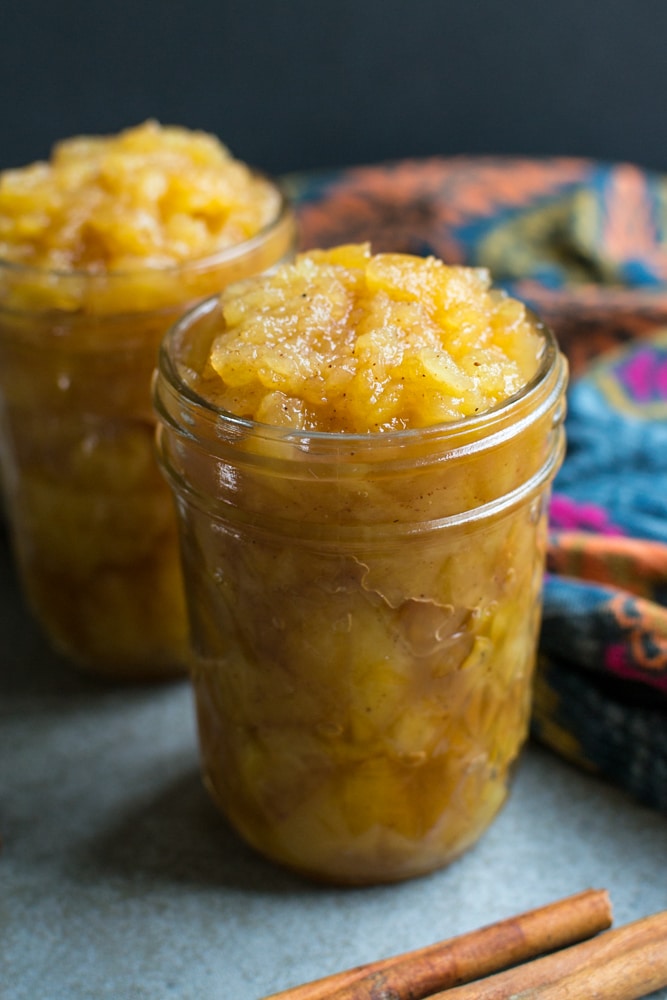 Cinnamon Homemade applesauce in glass jars, homemade fruit preserves, fall-inspired spread, cozy breakfast, any season.