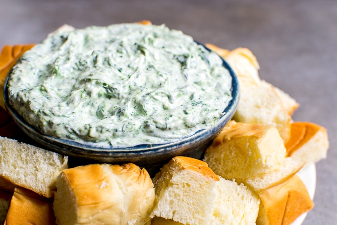 Creamy spinach and artichoke dip served with fresh bread and breadsticks, perfect for parties and snacks. Rich, cheesy, and flavorful appetizer for all occasions.