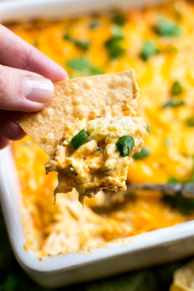 Creamy buffalo chicken dip with green onions, served with tortilla chip, savory cheese appetizer, easy party dip, cheesy snack, baked appetizer, cheesy chicken dip, crowd-pleasing party food, cheese dip recipe, quick appetizer.