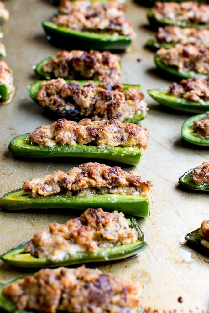 Stuffed jalapeño peppers topped with a savory ground meat mixture, baked to perfection, served as a delicious appetizer from Stuck On Sweet.