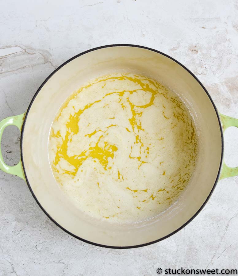 Creamy butter mixture in a light green pot for baking or dessert recipes.