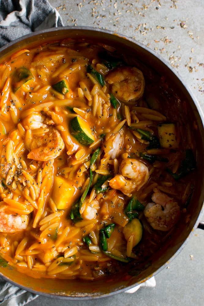 Creamy shrimp and vegetable pasta dish in a flavorful orange sauce with zucchini and orzo pasta. Perfect for a quick seafood dinner with fresh ingredients.