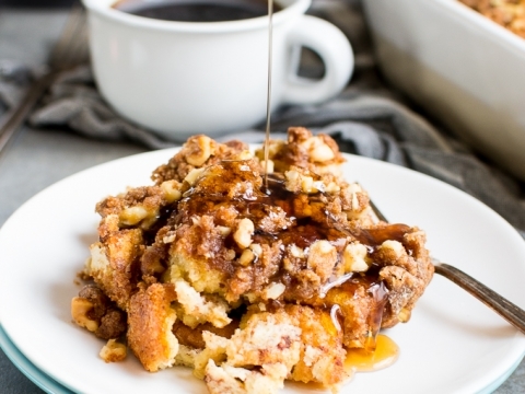 Gooey caramel apple cobbler with streusel topping drizzled with warm caramel sauce and served with a cup of black coffee, perfect for fall dessert.
