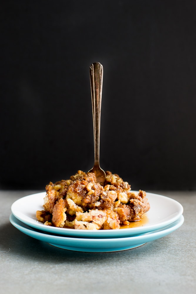 Butterfinger crumble pie topped with caramel and chopped nuts on a white plate with a vintage fork.