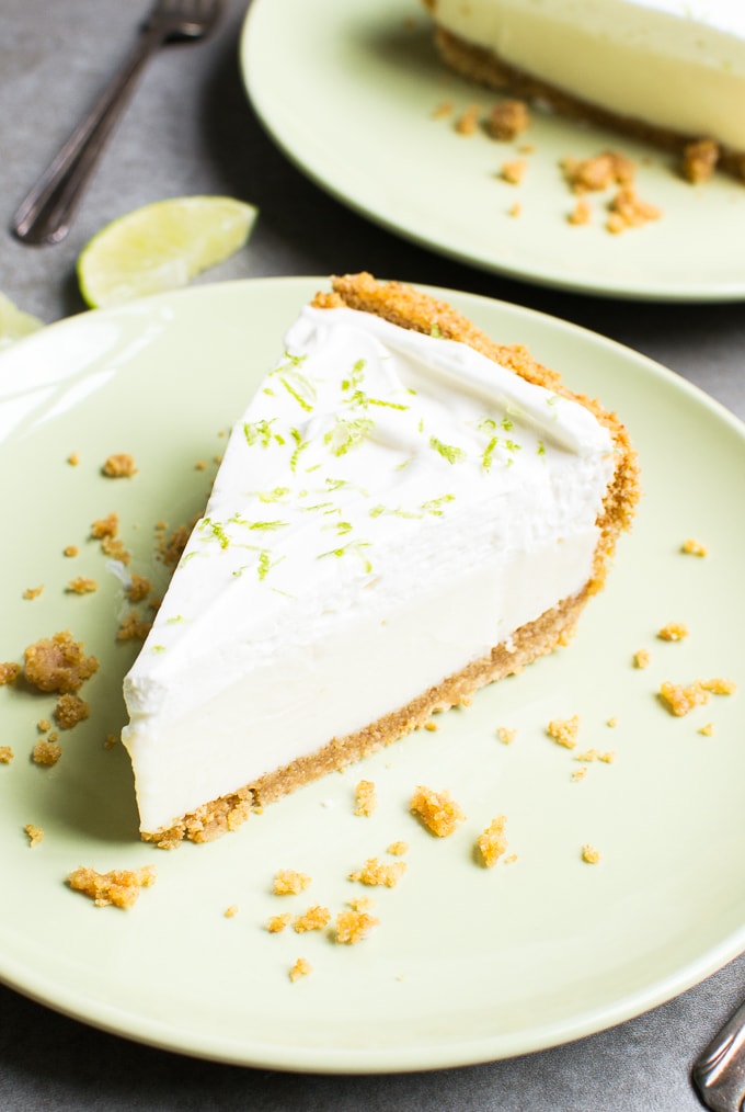 Rich and creamy key lime cheesecake with graham cracker crust, topped with lime zest, served on a pastel green plate. Perfect for a delicious dessert or party treat.