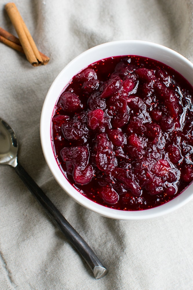 Rich homemade cranberry sauce in a white bowl, perfect for desserts and breakfast recipes.
