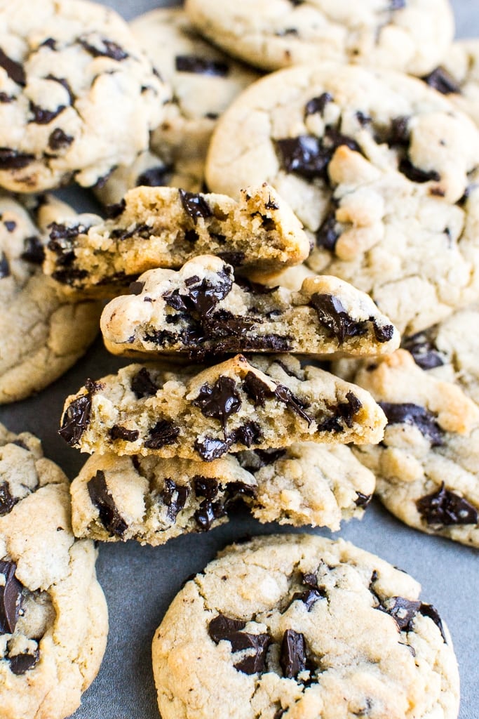 Buttery chocolate chip cookies with chunks of melted chocolate, fresh out of the oven, on a baking sheet.
