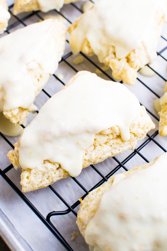 Buttermilk scones with white icing glistening on top, fresh baked scones cooling on a wire rack, soft and flaky scones drizzled with creamy icing, delicious homemade scones perfect for breakfast or tea, sweet bakery treats from Stuck On Sweet.