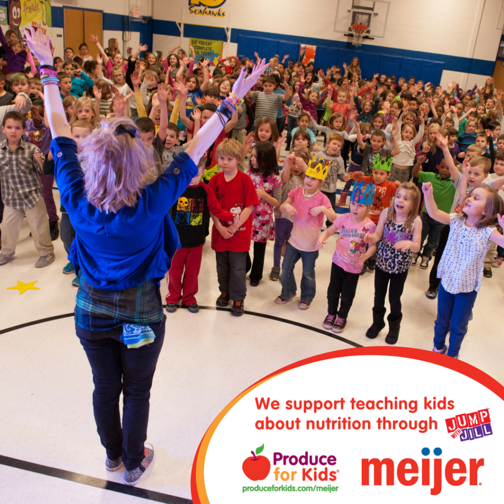 Kids cheering in school gymnasium for nutritious food awareness event.
