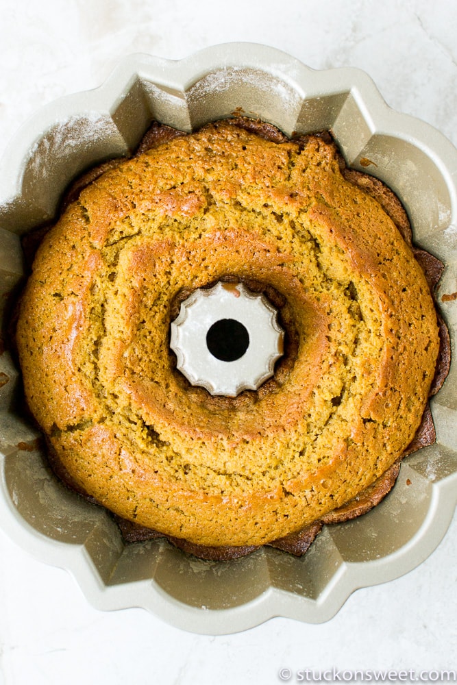 Rich, golden-brown spiced pumpkin bundt cake baking in a floral-shaped silicone pan, ready to be served as a delicious sweet treat.