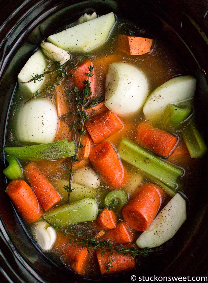 Slow cooker vegetable broth with carrots, potatoes, celery, and herbs for healthy homemade soup options.