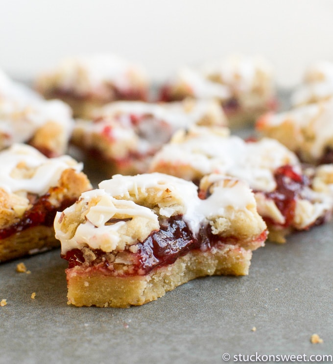 Cherry fruit crumb bars with white icing and almond topping, perfect for sweet desserts and snack recipes.