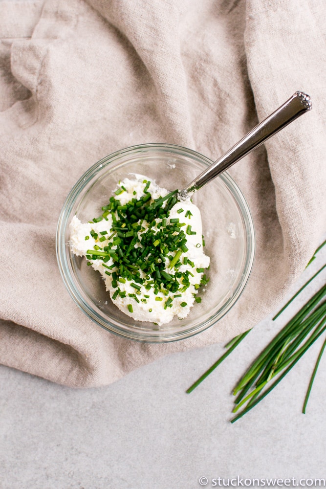 Cream cheese with chopped chives in glass bowl Ready for spreading on bagels or muffins, this flavorful herb cream cheese adds a fresh taste to breakfast and brunch. Perfect for homemade spreads and party finger foods.