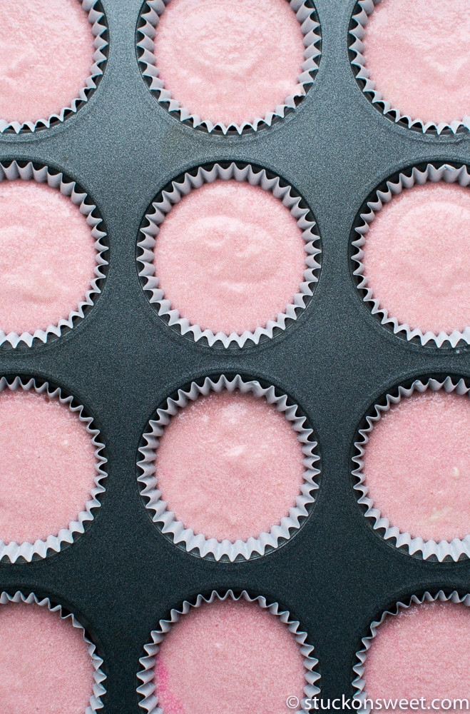 Bright pink cupcake liners in a baking tray, perfect for rainbow or colorful cupcake decorating. Great for baking cupcakes for parties, birthdays, or special events.