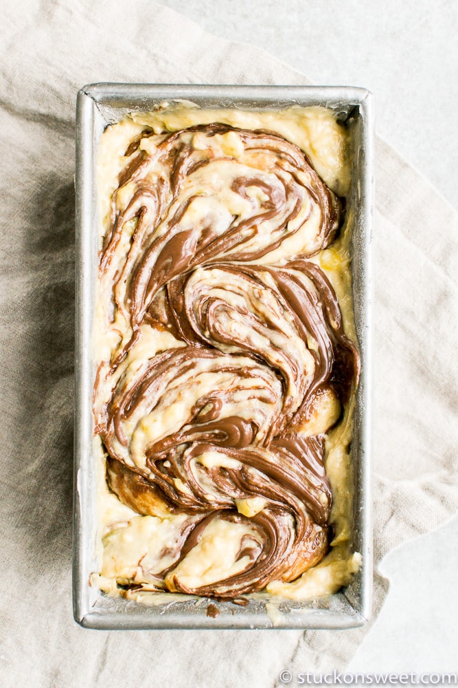 Marble cinnamon roll bread pudding with creamy custard and chocolate swirl topping in a baking dish.
