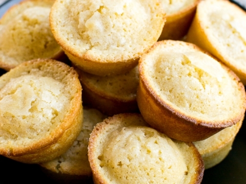 Fluffy vanilla cupcakes with golden crust in a black bowl, topped with fresh baked aroma. Perfect for sweet treat lovers and dessert recipes.