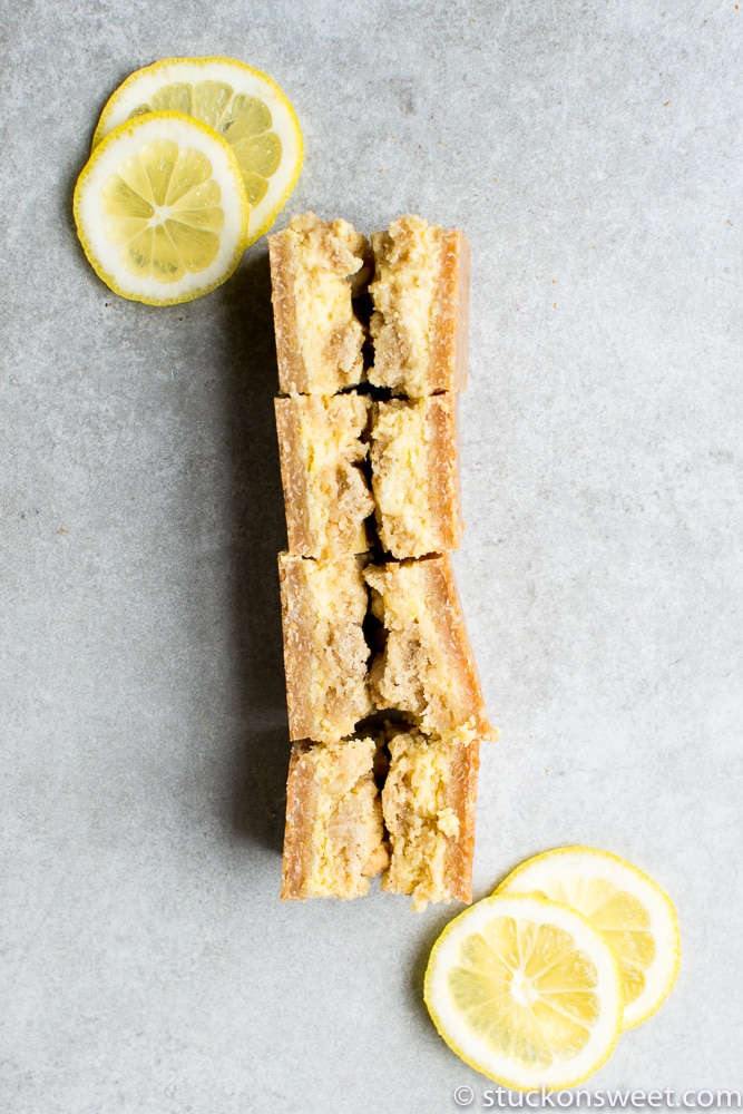 Lemon bars with fresh lemon slices on a gray background, perfect for sweet dessert lovers and citrus fans. Great for homemade dessert recipes and bakeries.