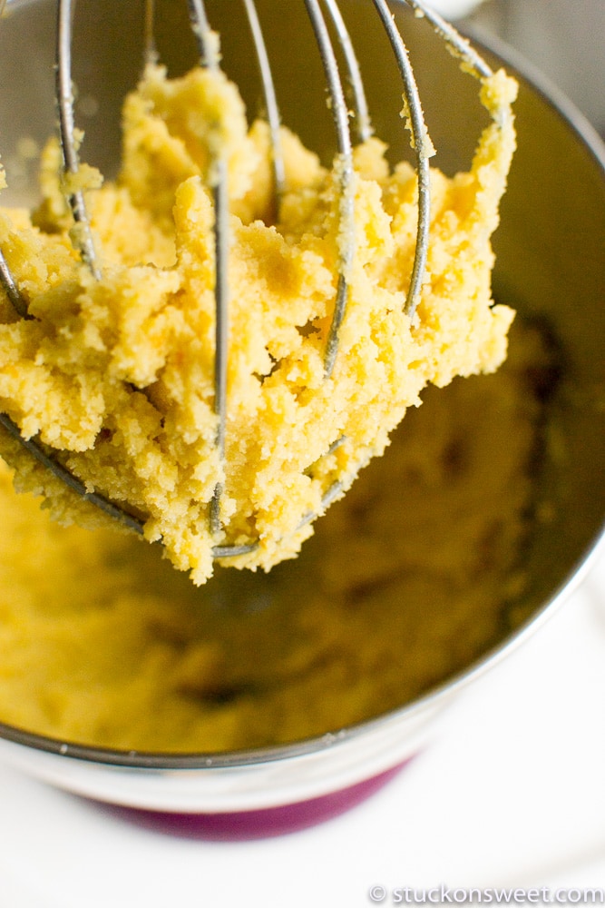 Creamy yellow cake batter on a mixer attachment ready for baking.