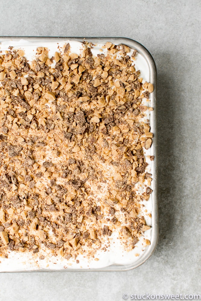 Creamy no-bake icebox cake topped with crushed cookies and chocolate shavings, perfect for a quick, indulgent dessert or summer treat.