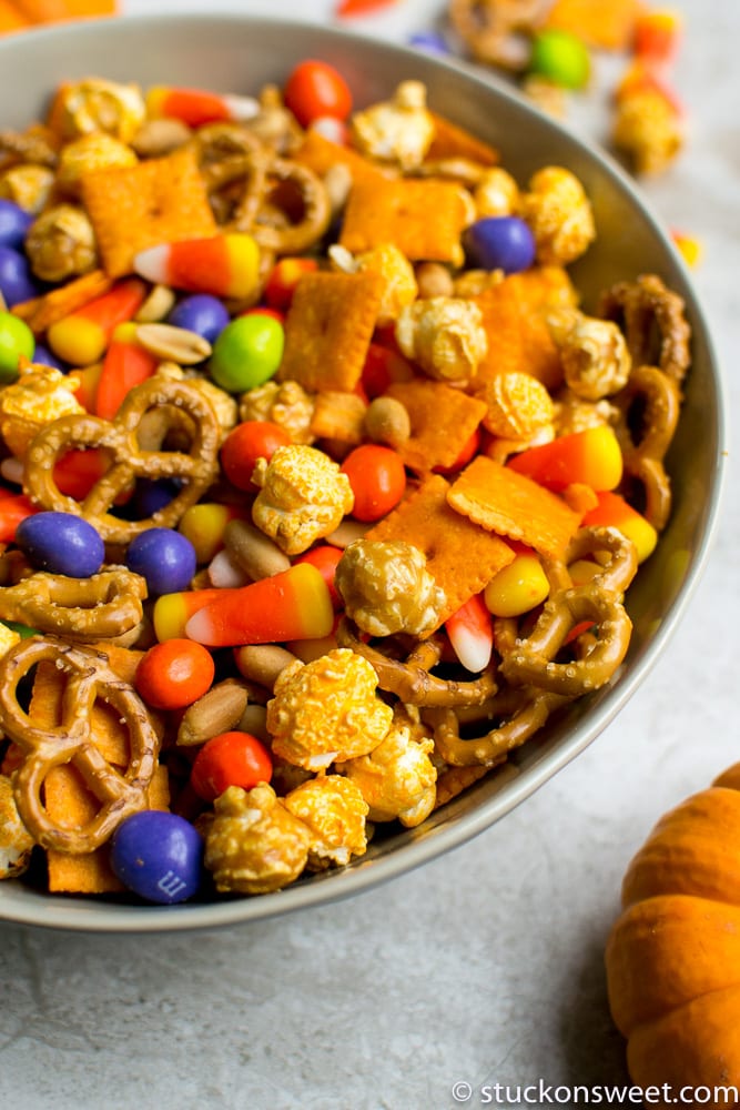 Chocolate Halloween candy mix with pretzels, popcorn, and candy corn in a bowl.