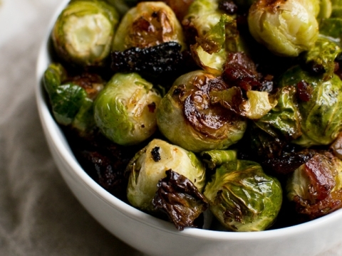 Roasted Brussels sprouts with bacon in a white bowl, showcasing a healthy and flavorful vegetable side dish. Perfect for dinner or holiday meals, emphasizing crispy, caramelized Brussels sprouts.