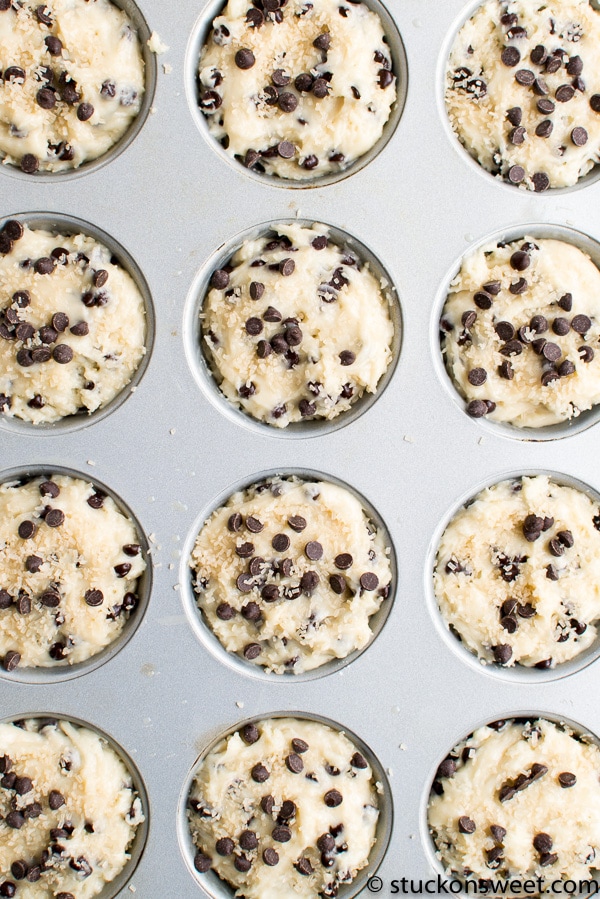 Chocolate Chip Cookie Dough Muffins baking in a muffin tin, ready to be cooked, featuring chocolate chips and cookie dough texture.