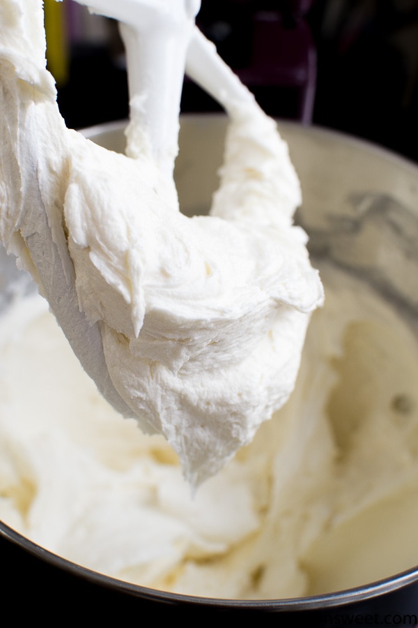 Fluffy creamy vanilla frosting being mixed in a stand mixer for cake decorating.