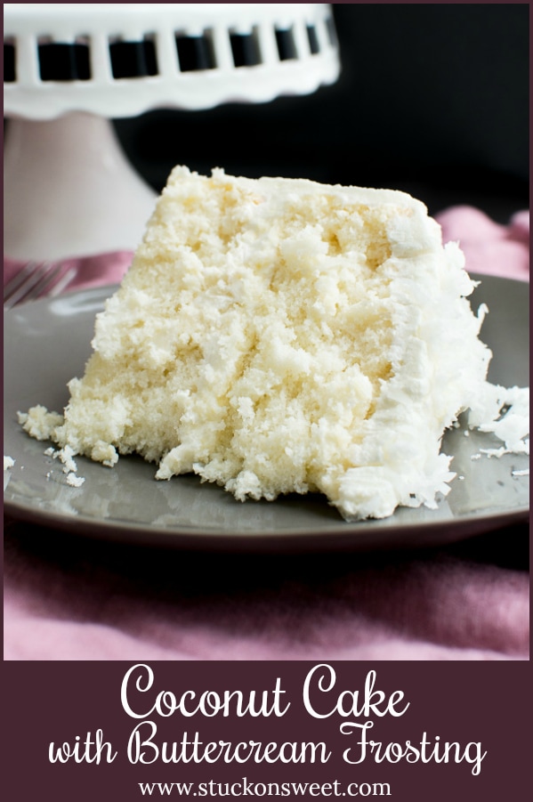Fluffy slice of coconut cake with buttercream frosting on a gray plate, perfect for dessert or celebration occasions.