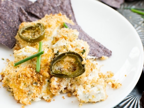 Crispy jalapeno poppers with ranch dip and purple tortilla chips on white plate.