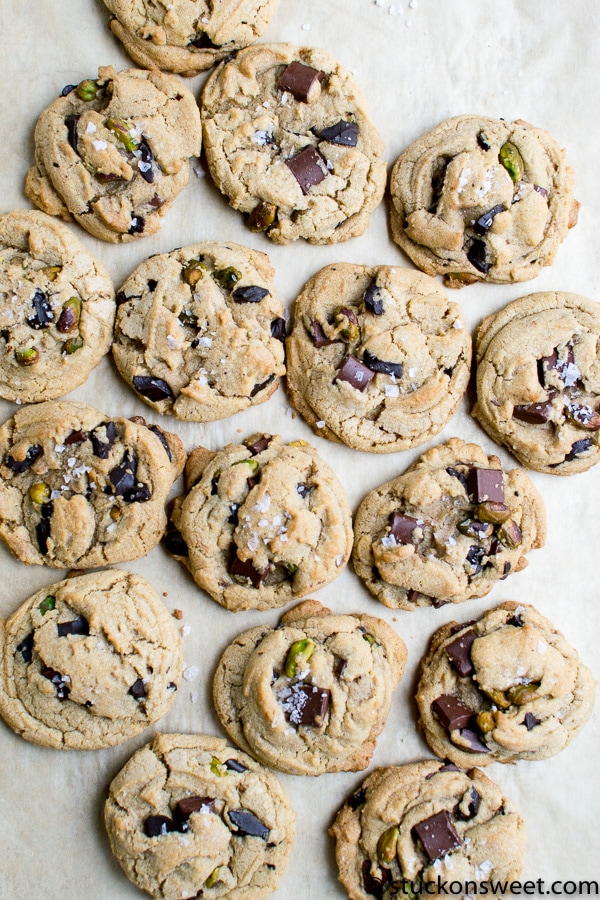 Delicious chocolate chip cookies with pistachios on parchment paper.