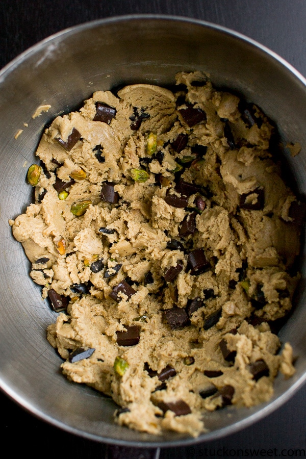 Rich chocolate chip and pistachio cookie dough with a creamy texture in a mixing bowl.