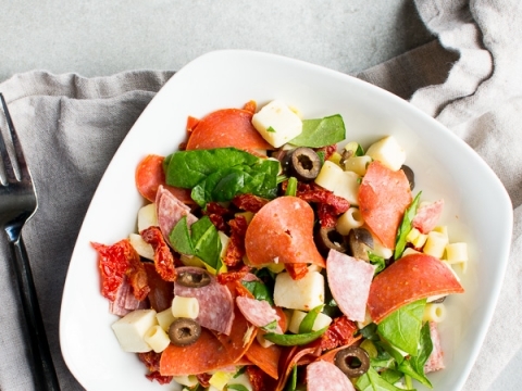Slices of deli meats, cheese, olives, and fresh greens in a salad bowl for a quick, easy, and delicious meal or snack. Perfect for a light lunch or healthy appetizer with fresh ingredients.