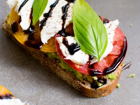 Fresh bruschetta topped with tomatoes, mozzarella, basil, and balsamic glaze on whole grain bread, perfect for a flavorful appetizer or snack.