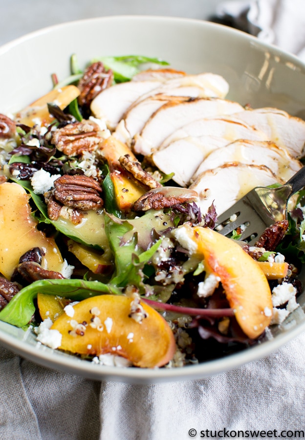 Fresh chicken Caesar salad with mixed greens, peach slices, toasted pecans, blue cheese crumbles, and a creamy dressing. Perfect for a healthy, flavorful meal.