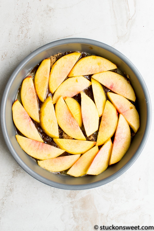 Peach slices arranged in a baking dish for peach cobbler recipe.
