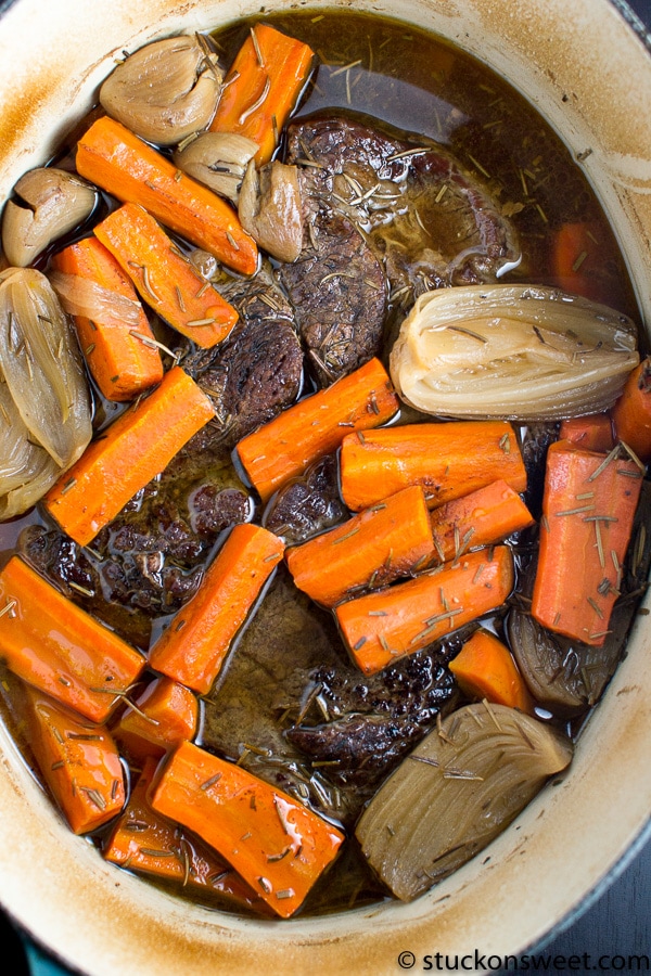 Braised beef stew with carrots and onions in a savory broth, close-up, hearty comfort food, perfect for cold weather meals, delicious home-cooked dinner, Stuck On Sweet.