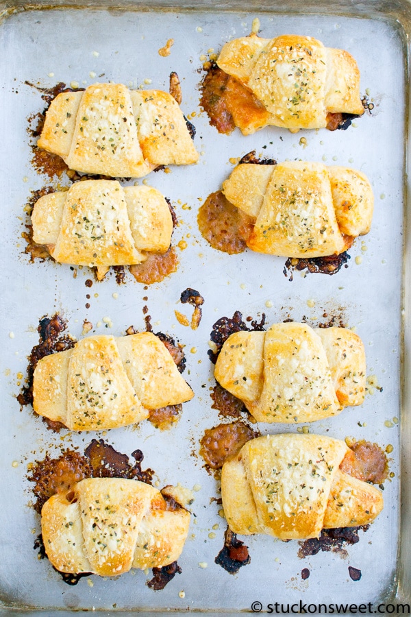 Cheesy stuffed mushroom caps with herbs on baking sheet for delicious appetizers.