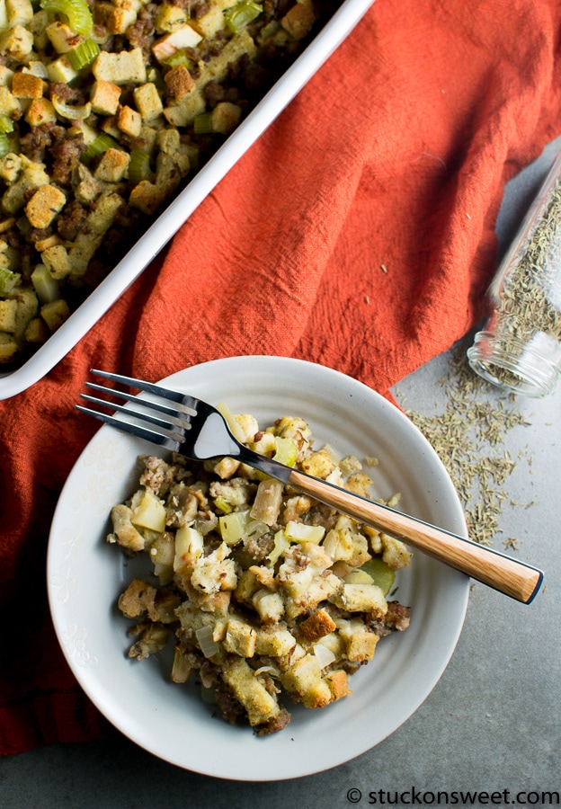 Creamy chicken and stuffing casserole served on a white plate, with additional casserole in a baking dish, garnished with fresh herbs, perfect for Thanksgiving or holiday family dinners.
