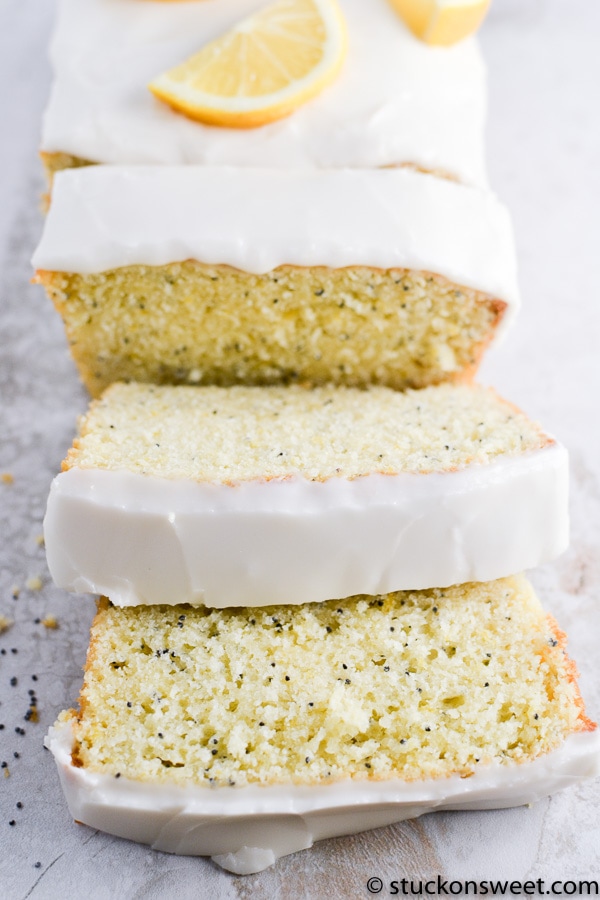 Lemon poppy seed cake with white icing and lemon slices on top, close-up.