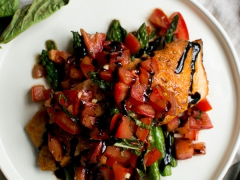 Grilled salmon topped with cherry tomato salsa, fresh herbs, and balsamic glaze served on a white plate. Perfect for healthy, flavorful dinner or lunch recipes.