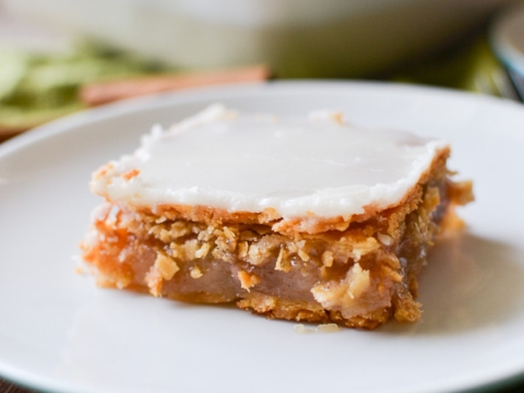 Rich, decadent peanut butter rice krispie treat bar topped with melted white chocolate on a white plate. Perfect for parties or a sweet snack.