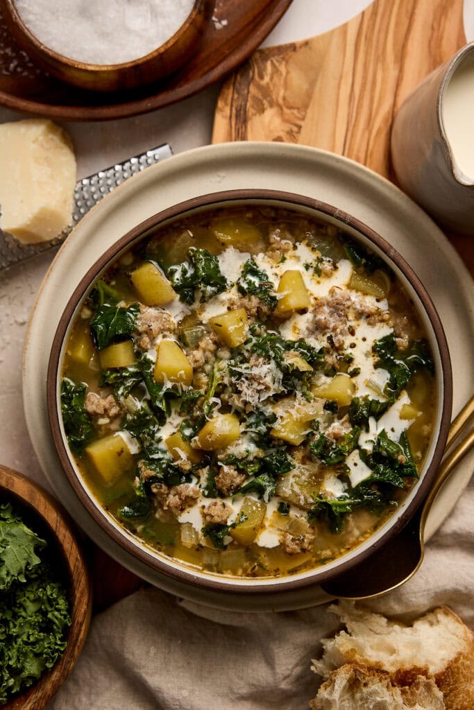 Hearty Zuppa Toscana soup with kale, potatoes, sausage, and cream served in a bowl, perfect for comforting meals.